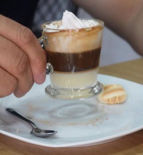 Café em copo de vidro com natas e bolacha